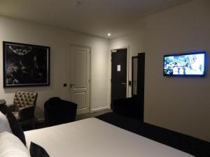 فندق ساراز البوتيكي في أمستردام: غرفة فندق فيها سرير وتلفزيون على الحائط