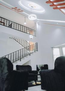 ein Wohnzimmer mit 2 Stühlen und einer Treppe in der Unterkunft Arusha Kwetu Villa in Sokon