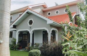 ein weißes Haus mit einem orangefarbenen Dach in der Unterkunft Arusha Kwetu Villa in Sokon