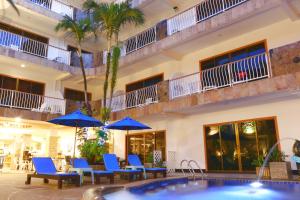 a hotel with a pool and chairs and umbrellas at Baan Boa Resort in Patong Beach