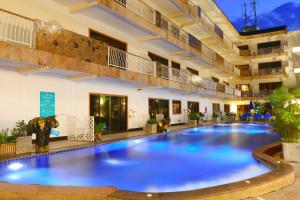 a large swimming pool in a large building with a building at Baan Boa Resort in Patong Beach