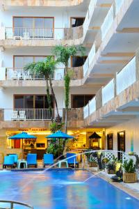 a hotel with a swimming pool with chairs and umbrellas at Baan Boa Resort in Patong Beach