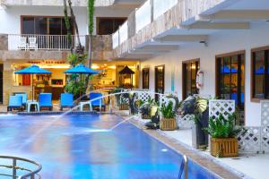 a pool in a hotel with blue chairs and umbrellas at Baan Boa Resort in Patong Beach