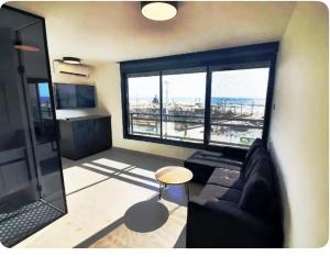 a living room with a couch and a large window at Ryo 11 דירת נופש חדשה על חוף הים נוף לים in Bat Yam
