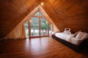 a bedroom with a bed in a room with a large window at Trishuli Villa in Benighāt +42 photos