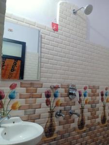 Un baño con un lavabo y dos jarrones con flores. en Hotel City Crown Lamahi Dang, en Namāi