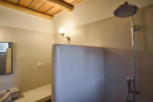 a bathroom with a stainless steel refrigerator in a room at Elegantly restored traditional cottage in Logothetiánika