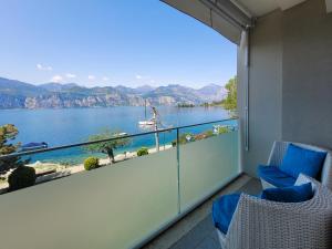 un balcon avec deux chaises et une vue sur l'eau dans l'établissement La Vista Val di Sogno Malcesine, à Assenza di Brenzone