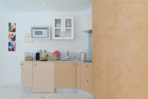 a kitchen with white cabinets and a microwave at AQUABLANCA Suite Love Deluxe en Punta Mujeres in Punta de Mujeres