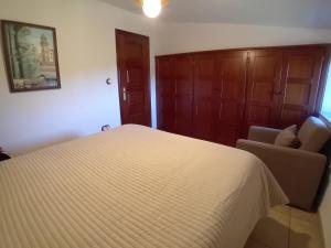 a bedroom with a bed and a couch and a chair at Stone Cottage La COMPOSTELANA in Curtis