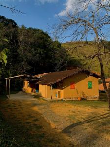 una casa con puertas de colores a un lado. en Fazenda Rio Do Peixe eventos e confraternizações, en São Francisco Xavier