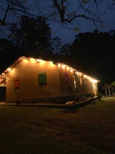 Una casa con luces en el costado por la noche. en Fazenda Rio Do Peixe eventos e confraternizações, en São Francisco Xavier