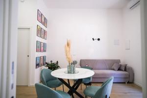 a living room with a table and chairs and a couch at Euphemia Glamour Apartment in Reggio Calabria