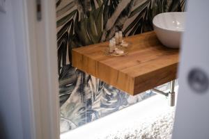 a bathroom with a wooden table and a sink at Euphemia Glamour Apartment in Reggio Calabria