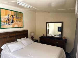 ein Schlafzimmer mit einem Bett und einem großen Spiegel in der Unterkunft My beautiful small house in Point E