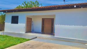 a small white house with two doors at Casa Rose Roraima · Casa em Boa Vista com piscina, ar condicionado in Boa Vista