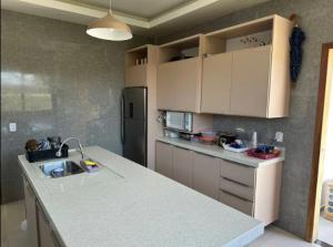 a kitchen with a counter top and a refrigerator at Casa Rose Roraima · Casa em Boa Vista com piscina, ar condicionado in Boa Vista