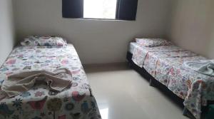 a bedroom with two beds and a window at Casa Rose Roraima · Casa em Boa Vista com piscina, ar condicionado in Boa Vista +9 photos