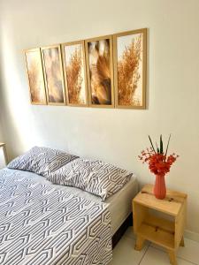 una camera da letto con un letto e un vaso di fiori su un tavolo di Apartamento 108 a Caruaru