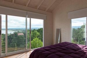 a bedroom with a bed and large windows at Dique Los Molinos Exclusiva casa vista al lago in Cordoba +128 photos