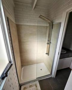 a shower with a glass door in a bathroom at Dique Los Molinos Exclusiva casa vista al lago in Cordoba