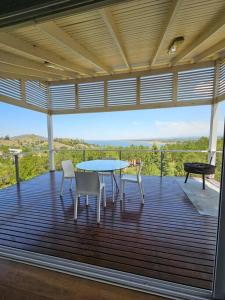 a patio with a table and chairs on a deck at Dique Los Molinos Exclusiva casa vista al lago in Cordoba