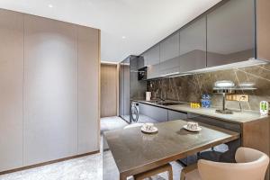 a kitchen with a table and some chairs at BaiYue Apartment - Zhujiang New City Guangzhou in Guangzhou