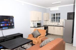 a kitchen and living room with a couch and a table at Maranzhe Villa in Musina