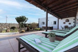 a patio with green lounge chairs on a roof at Casa Aloe in Teseguite