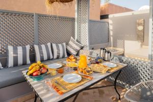 a tray of food on a table on a balcony at Riad SWAN-exclusif - Piscine chauffée - Petit déjeuner in Marrakech