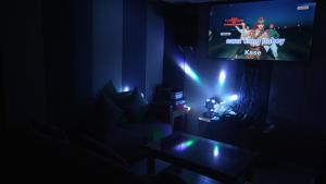 a living room with a tv in a dark room at BAIA Laiya Marienella Resort in San Juan