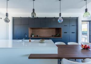 eine Küche mit einer weißen Theke und einem Tisch in der Unterkunft La Californienne - Villa contemporaine design in Sauvian