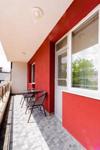 a balcony with a table and chairs and a window at Апартамент Веирас 2 in Velingrad