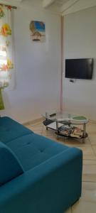 a living room with a blue couch and a table at Bikamado in Deshaies