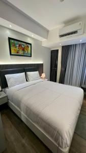 a bedroom with a large white bed in a room at Pollux Habibie batam in Batam Center