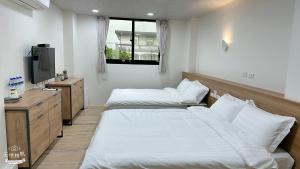 Postel nebo postele na pokoji v ubytování Fulong City B&B