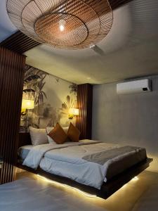 a bedroom with a large bed with a chandelier at BAIA Laiya Marienella Resort in San Juan