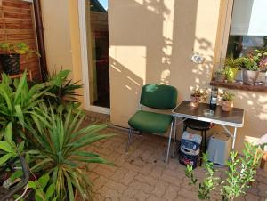 a table and a green chair sitting next to a building at Stella's Monteurswohnungen in Crimmitschau