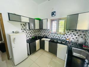 a kitchen with black and white appliances and a refrigerator at The Falls at Mangal Caverns in Vagamon