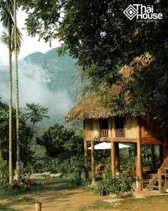 una casa con il tetto di paglia nella giungla di Thai House Pu Luong - Century Old Stilt House with Terrace Views a Hương Bá Thước