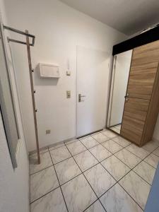 ein leeres Zimmer mit Tür und Fliesenboden in der Unterkunft Big Apartments in Dortmund