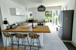 a kitchen with a large island with bar stools at Maison avec jardin proche du centre et des plages in Carantec