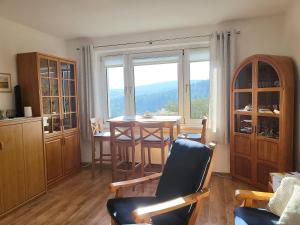 a living room with a table and a large window at FeWo Bergblick - Oberwiesenthal in Kurort Oberwiesenthal