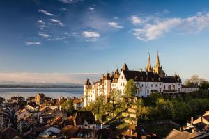 a view of a town with a castle and water at Comfortable 1 bd apt in Peseux