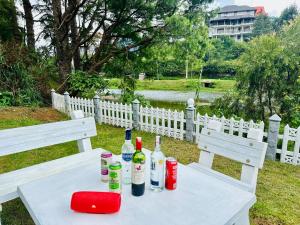 un tavolo bianco con bottiglie di vino sopra di Lakeside Cottage by Clover a Nuwara Eliya