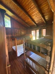 Un dormitorio con dos literas en una cabaña. en Cabañas vacacionales Lefincul, en Pucón