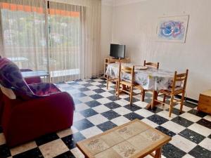 a living room with a table and chairs and a tv at Charmant F2 avec Garage, Terrasse et Véranda, à 500m du Centre et 600m des Cures à Amélie-les-Bains - FR-1-703-131 in Amélie-les-Bains-Palalda
