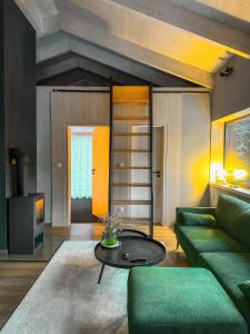 a living room with a green couch and a table at Eliška apartment - modern mountain loft apartment in Ski resort Malino Brdo in Ružomberok