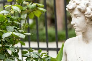 a statue of a boy sitting next to a plant at Nafsimedon Hotel in Nafplio