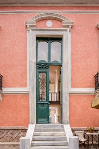 a green door on the side of a building at Nafsimedon Hotel in Nafplio